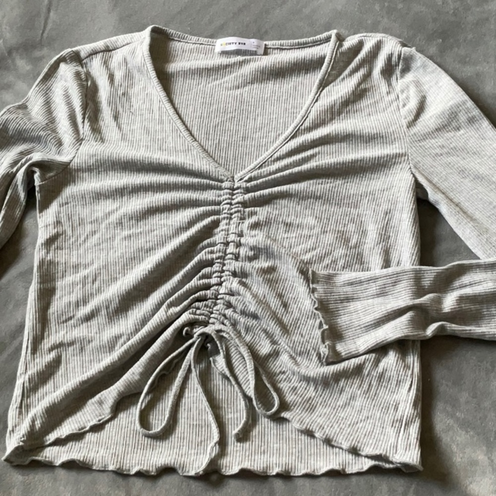 Small light grey long sleeve with adjustable ruffle down the middle